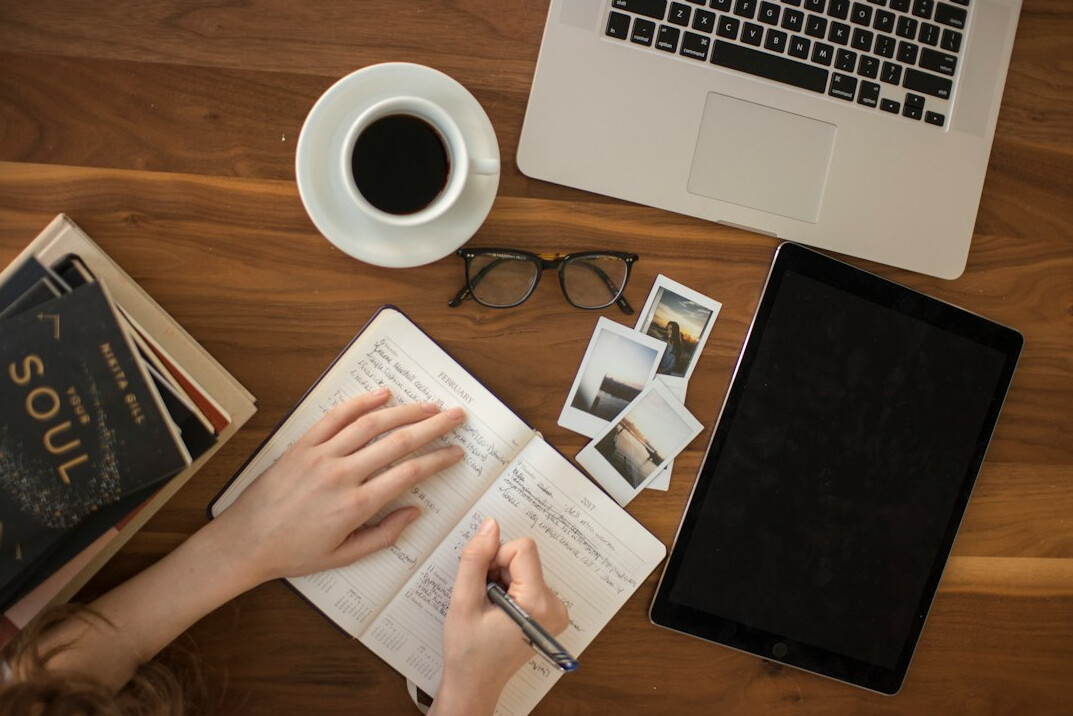 woman writing goals in notebook